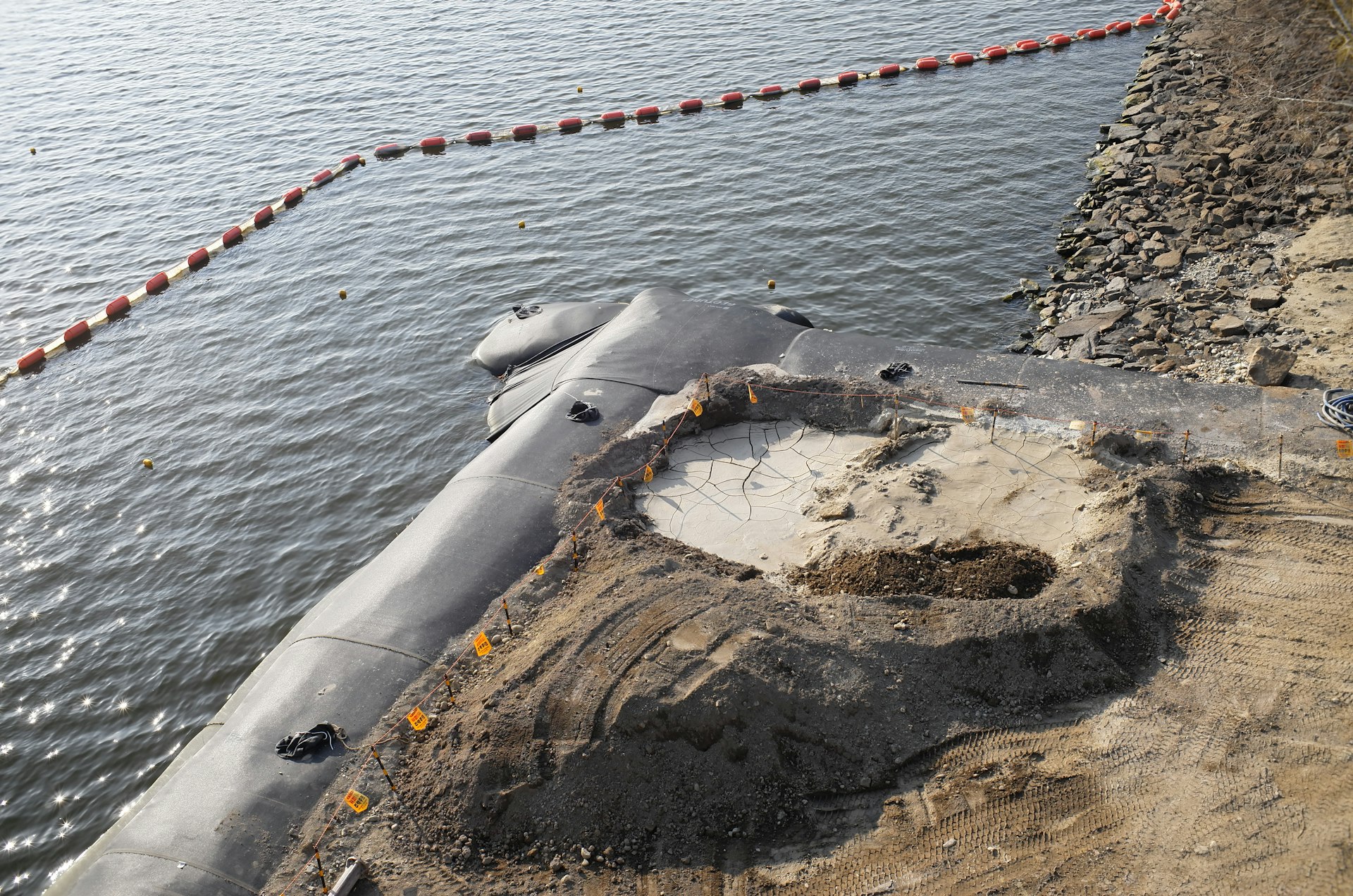 Construction site with a water barrier and rock embankment
